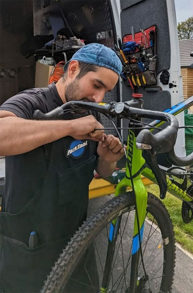 An image of Gabriel Avendaño fixing a bike.